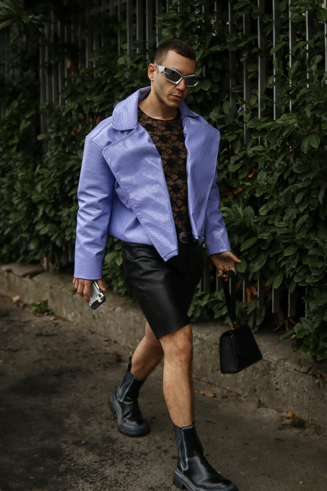 A man walking down a street wearing a purple jacket
