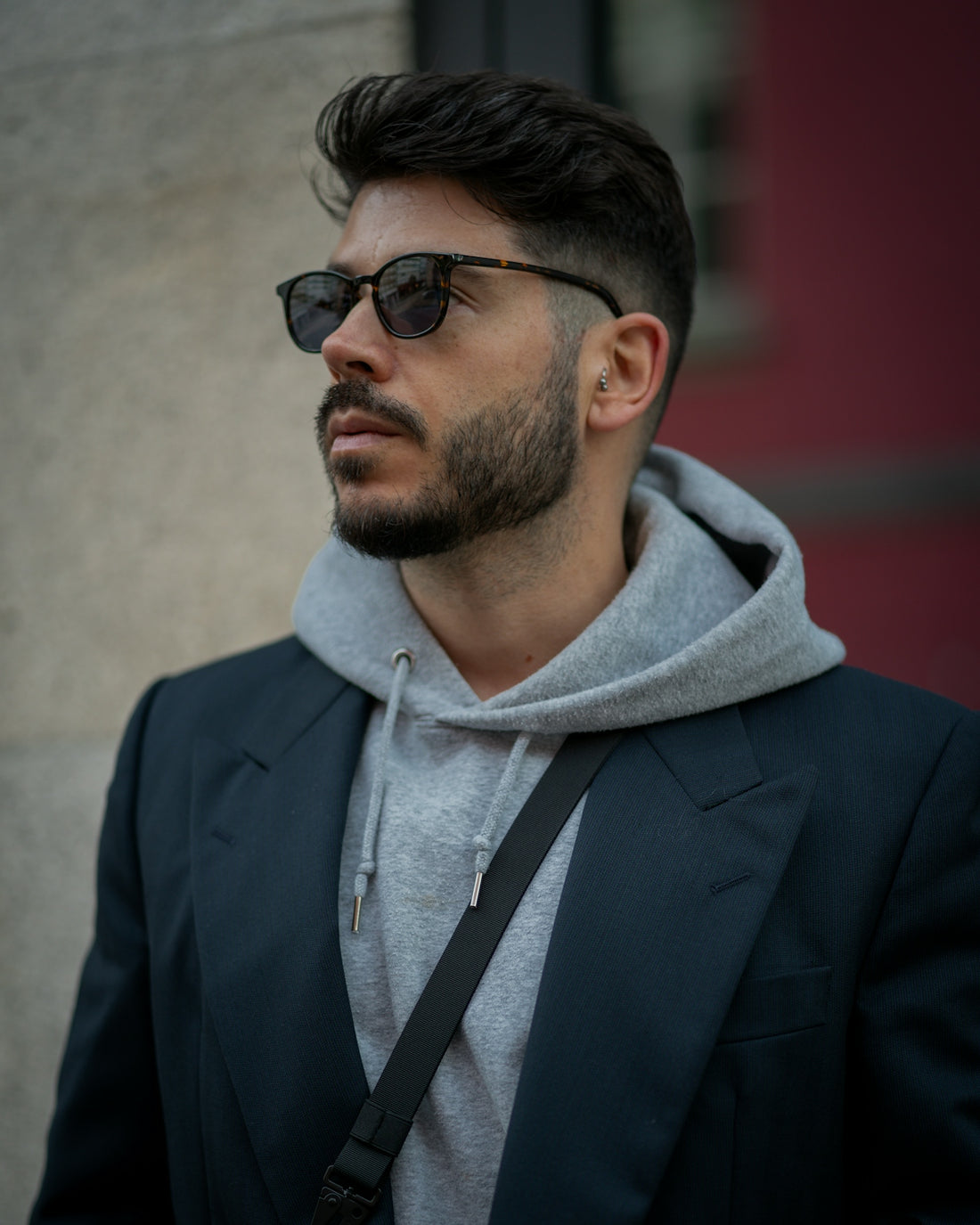 A man with a beard wearing sunglasses and a hoodie